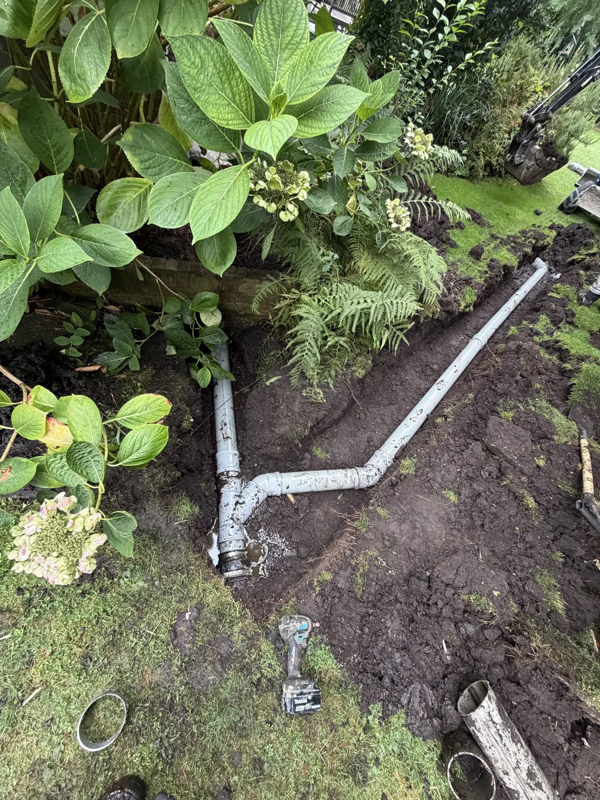 Nieuwe riolering met broekstuk in de tuin