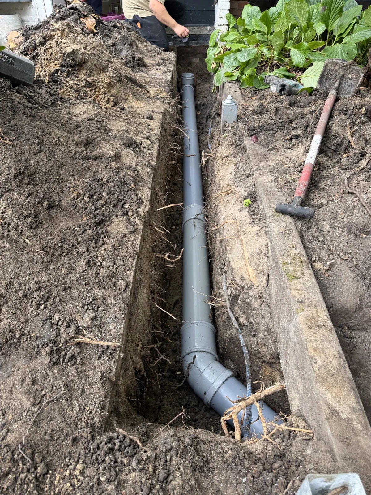 Nieuwe rioolleiding in een sleuf door de voortuin