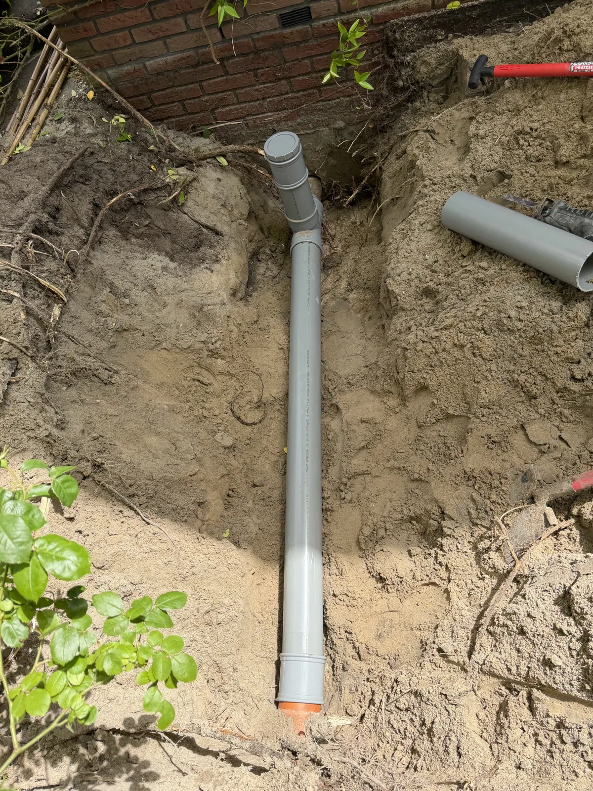 PVC-leiding met ontstoppingsstuk aangesloten op oude gresleiding
